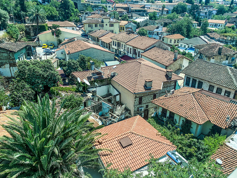 view from a height of a small settlement of local residents. small houses with tiled roofs against the backdrop of green palm trees. low houses next to the sea.