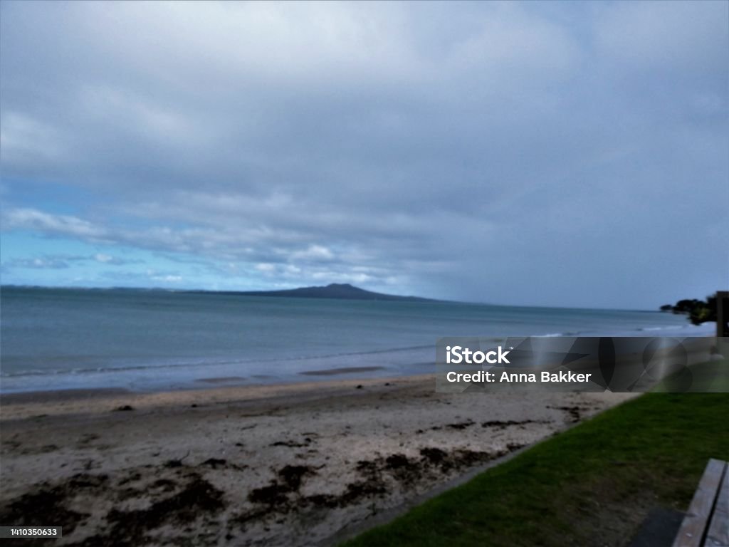 Rain clouds on the move at the Milford Beach, Auckland A shot was taken as rainclouds is passing over the Rangitoto Island from Milford beach. Auckland Stock Photo