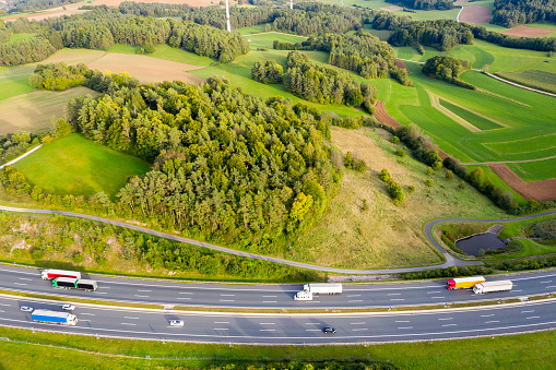 Aerial view of multiple lane highway with trucks.