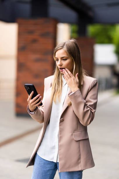 istock Young woman using phone walking on the street 1410352966