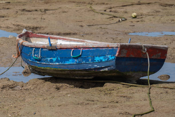 Close-up of an old blue rowing boat at low tide on the beach in Cadiz
