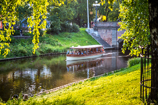 Riga, Latvia - August 7, 2019: Boat on a canal in Kronvalda park of Riga at sunset in summer. Latvia