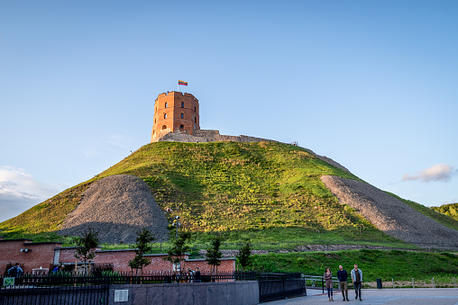 Vilnius, Lithuania - August 9, 2019: Gediminas Tower with Lithuanian flag against the clear blue evening sky, Vilnius, Lithuania