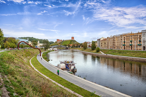 Embankment of Neris river in Vilnius this Gediminas tower ruins in the background, Lithuania