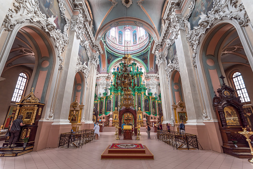 Vilnius, Lithuania - August 10, 2019: people praying and visiting the Orthodox Church of the Holy Spirit, Vilnius. the beautiful emerald colour interior design.