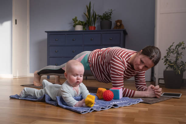 Mother with baby make yoga at home to be strong and healthy stock photo