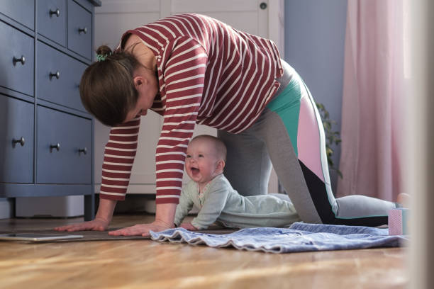 Mother with baby make yoga at home to be strong and healthy stock photo