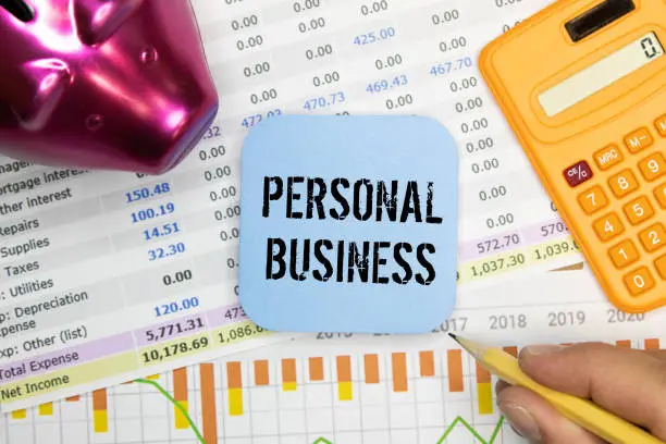 Photo of Business concept. On the puzzles lies a calculator and a pen, next to the inscription - Personal Finances.