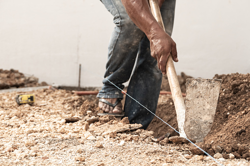Man digging a hole in the ground with shovel