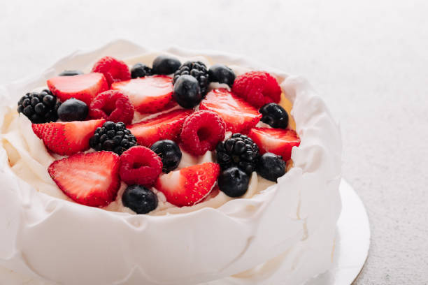 Pavlova meringue cake with fresh berries on white background