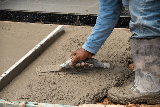istock mason's hands laying cement on the floor 1410358699