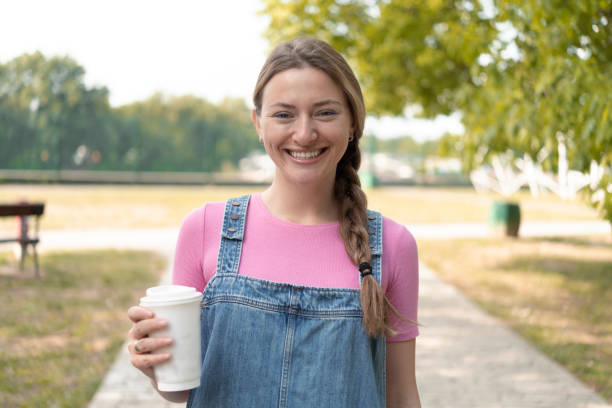 istock Girl standing on street with coffee 1410365811