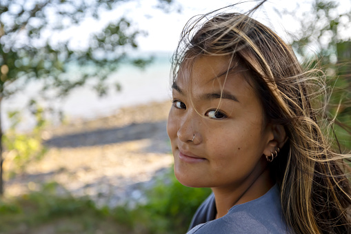 Natural beauty exudes from this young adult enjoying a sunny day by the ocean in New England.