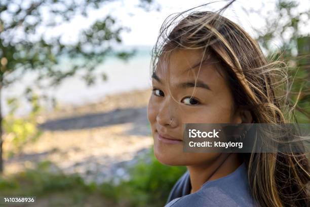 Gorgeous Chinese Woman Enjoys The Wind Blowing Through Her Hair By The Ocean In Maine Stock Photo - Download Image Now
