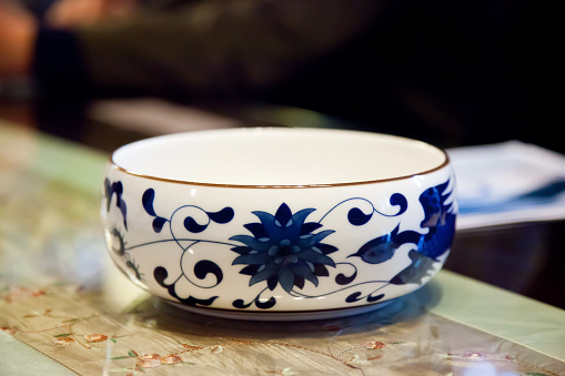 Antique porcelain vase with floral pattern on the wooden table