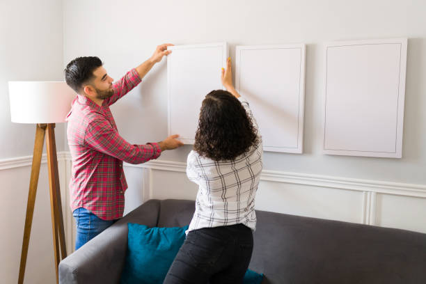istock Young couple putting decorations in their new home 1410381896