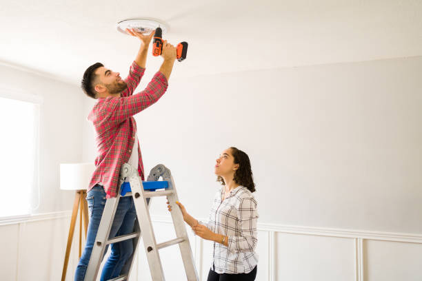 istock Handy couple fixing the lighting on the ceiling 1410382570