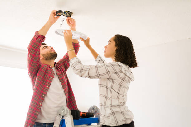 istock Handy couple fixing the electricity and lighting on the ceiling 1410382575