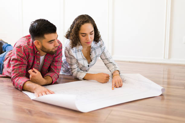 istock Beautiful caucasian couple looking at the construction plans 1410382743