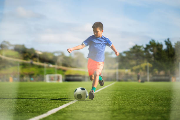 istock Boy training hard on the soccer ground. 1410390459