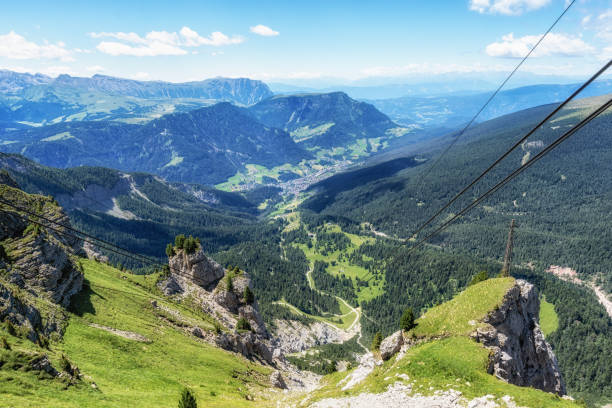 The view of Ortisei town taken from Seceda cable car. Alpine houses along the hills of Val Gardena. Dolomites, Italy