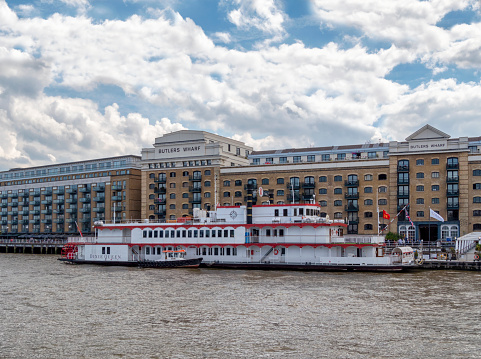 The ‘Dixie Queen’ paddle steamer moored at Butlers Wharf in the Pool of London near Tower Bridge on the River Thames, London. The boat is a replica paddle steamer which hosts functions, conferences and parties.