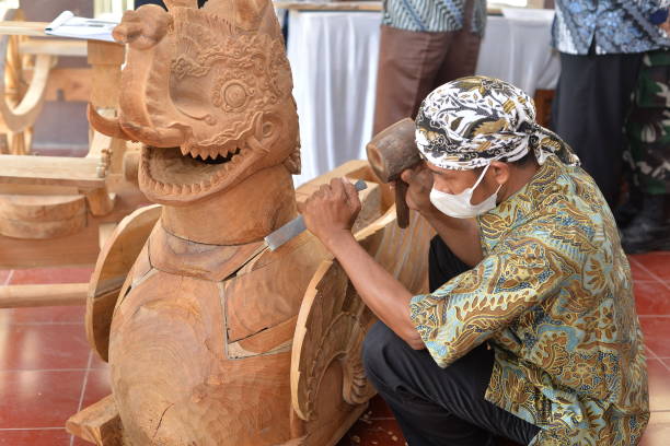 A Carpenter making traditional wood carving Paksi Nagaliman in Cirebon, Indonesia. Local craftmanship tradition concept September 09 2021, West Java - Indonesia : A Carpenter making traditional wood carving Paksi Nagaliman in Cirebon, Indonesia. Local craftmanship tradition concept lombok indonesia stock pictures, royalty-free photos & images