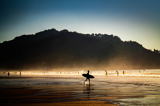 Silhouettes of surfers at the beach in Zarautz, Spain