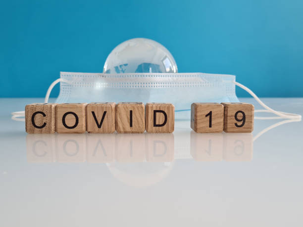 istock Text covid-19 medical mask and globe closeup 1410402195