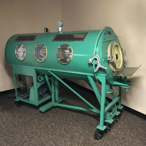 iron lung machine Iron lung on display at Tuskegee Institute National Historic Site, Tuskegee, Alabama, USA. Iron lungs were used to assist people paralyzed by polio to breath. polio virus photos stock pictures, royalty-free photos & images