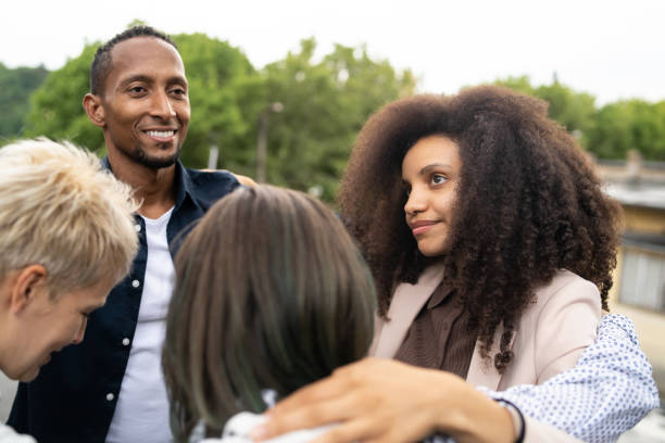 Smiling people supporting each other in a circle during therapy stock photo