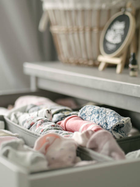 istock Baby clothes and bibs in a drawer with woven basket 1410408092