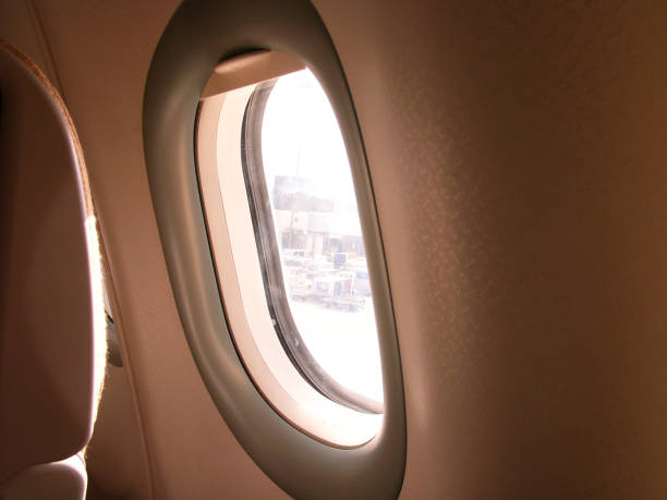 istock Typical airplane window from passenger seat view and dark background for wallpaper dreaming atmosphere concept 1410409314