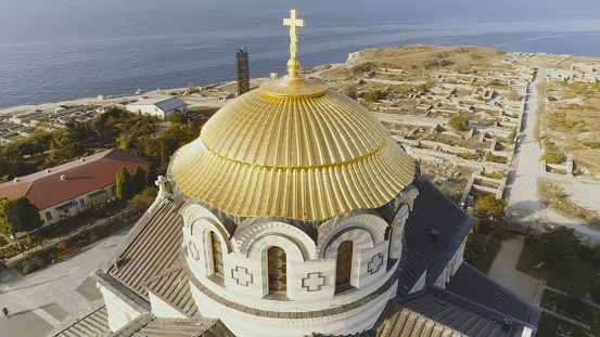Golden domes of the Orthodox Vladimir Cathedral in Chersonesos, on the background of blue sea. Shot. The largest temple on the Crimean Peninsula. Top view of the temple of Chersonesos.