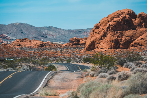 In Valley of Fire the road is running through the hot red rock desert landscape. Seen in Nevada, USA, a hot day in the summer.