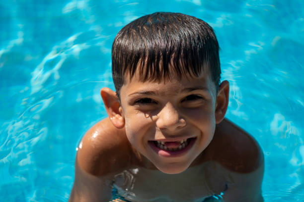 istock Little Rascal Boy is Enjoy Swimming In The Pool While Smiling and Posing 1410423514