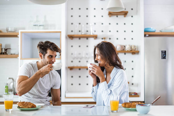 istock Young happy couple talking during morning time in the kitchen. 1410423615