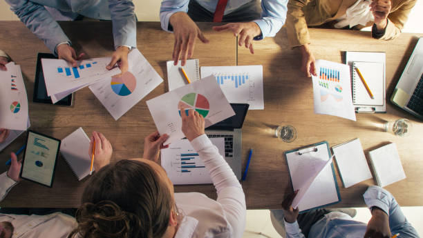 istock Business people analyzing and reviewing various project paperwork during a meeting 1410424990