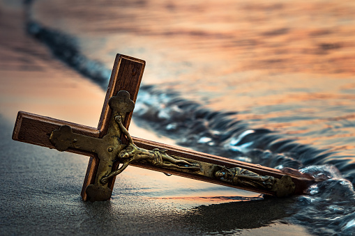 Wooden cross on the sea beach
