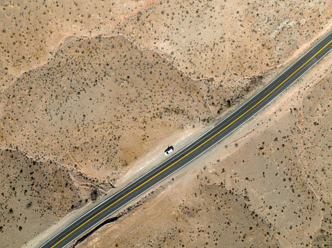 Cars driving on a straight open highway through desert landscape near Las Vegas in Nevada, USA. Seen directly from above.