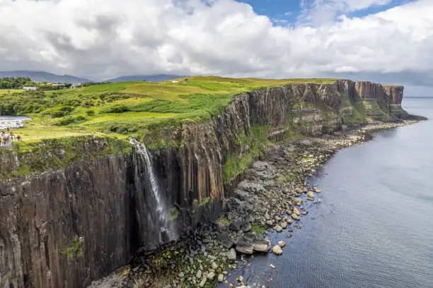 The waterfall from Loch Mealt falls 55 metres to the sea. Behind is Kilt Rock, 90 metres tall.