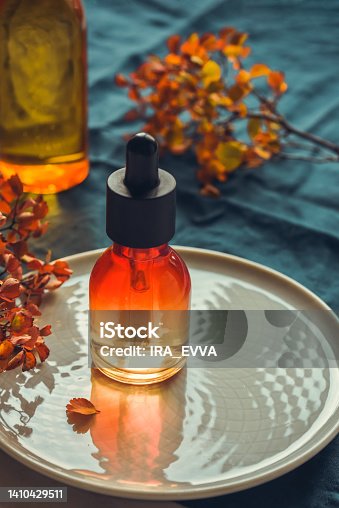 istock Emulsion with collagen, vitamin C serum in bottle with pipette on round dish Concept of natural anti-aging skincare 1410429511