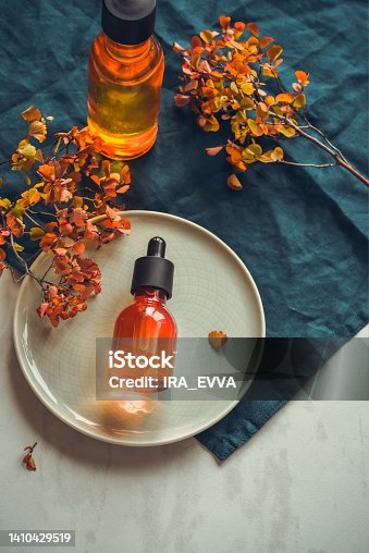 istock Emulsion with collagen, vitamin C serum in bottle with pipette on round dish Concept of natural anti-aging skincare 1410429519