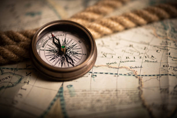 antique compass lying on old style map - compass direction antique guidance imagens e fotografias de stock