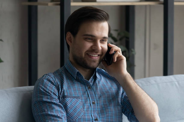istock Smiling handsome young man involved in pleasant smartphone conversation. 1410433613