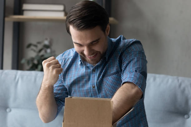 istock Happy young man celebrating getting order from internet store. 1410433638