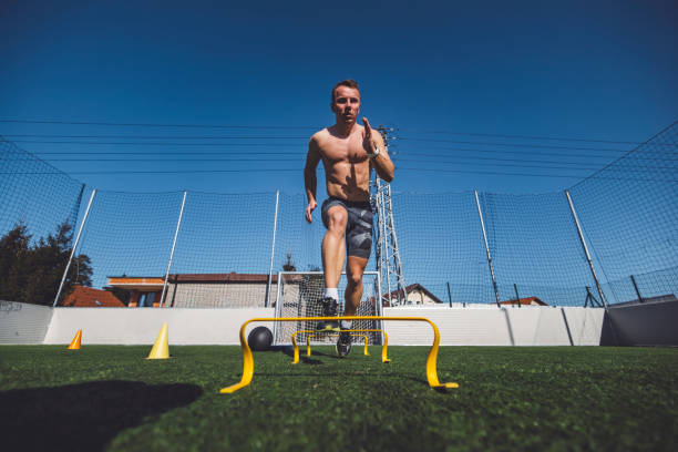 istock Low angle view of an athlete sprinting over obstacles 1410434070