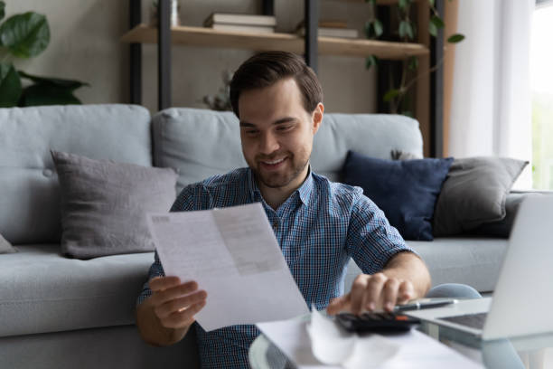 istock Happy millennial generation man doing domestic financial paperwork. 1410435027