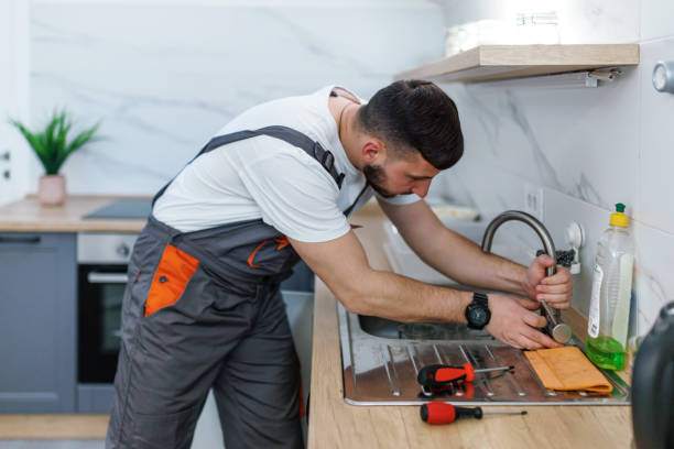 This faucet is leaking again A young Caucasian plumber is trying to tighten a leaking faucet on a kitchen sink. again stock pictures, royalty-free photos & images