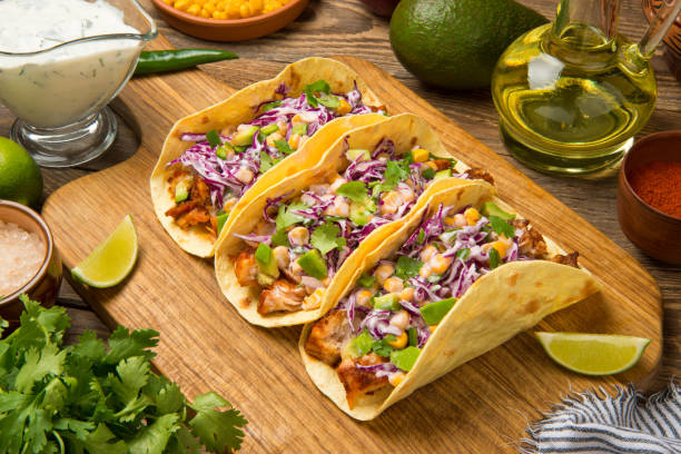 istock Fish tacos with ingredients on an old wooden table. 1410437239